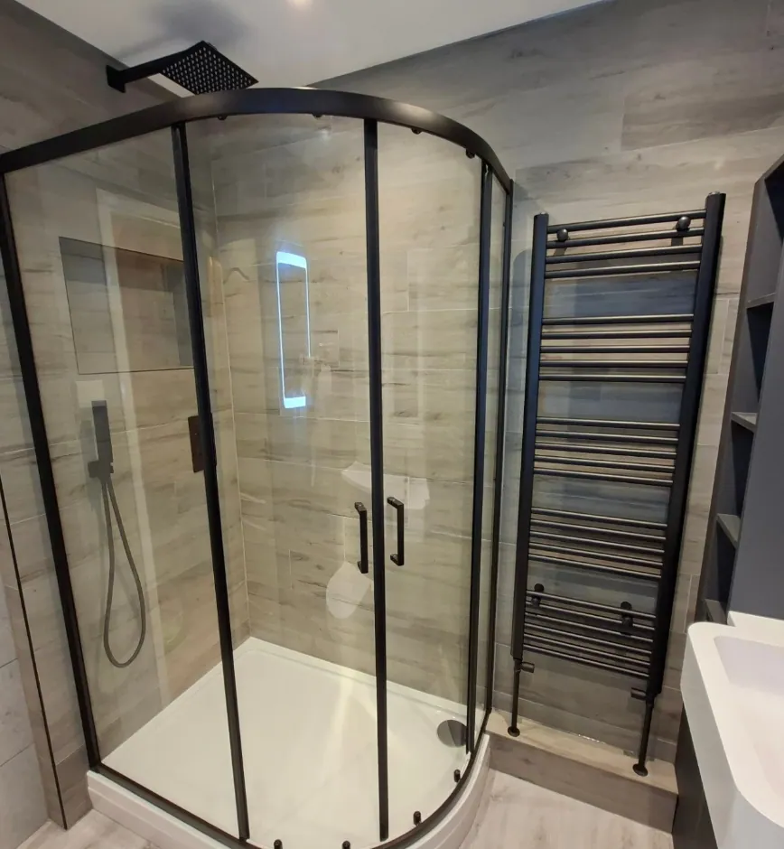 Quadrant walk-in shower with black frame and wood-effect tiles